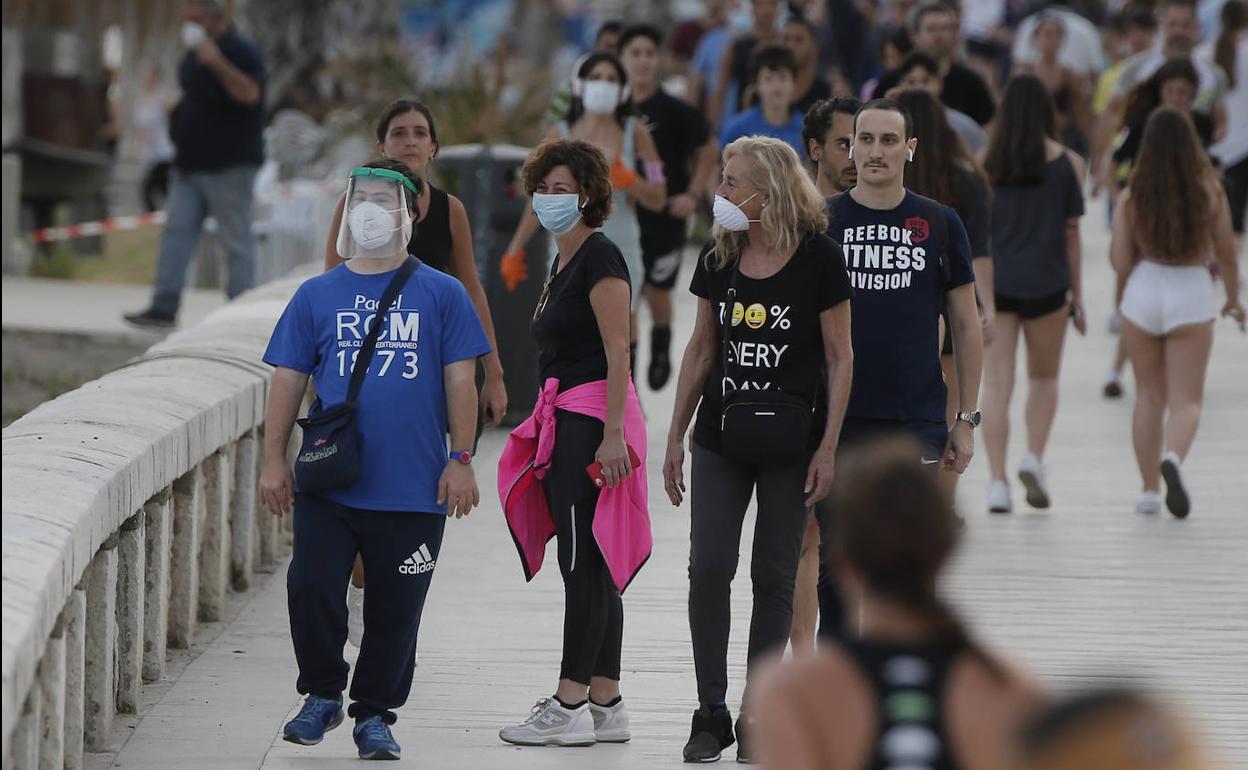 Ciudadanos pasean junto a la playa en la capital malagueña. 