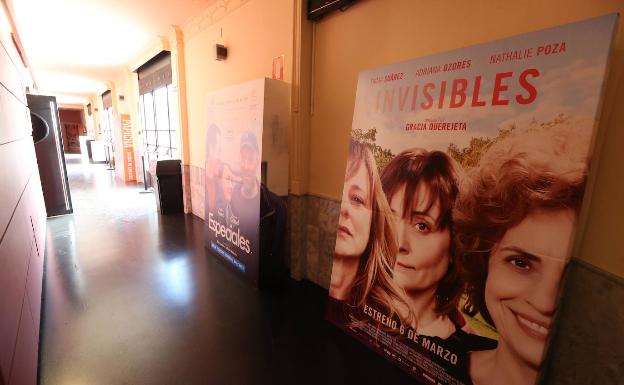 Imagen principal - Arriba, carteles de 'Invisibles' y 'Especiales', dos de las películas que se exhibían el día del cierre del cine por la pandemia. Abajo, Artacho explica la disposición del público con las restricciones de aforo y pizarra de la cabina con las películas del pasado 13 de marzo. 