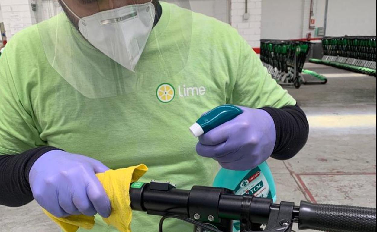Un operario limpia un patinete en la base de Lime en Málaga, donde volverá a operar a partir del lunes. 