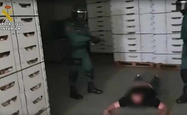 Dos agentes de la Guardia Civil, junto a uno de los detenidos. 