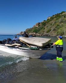 Imagen secundaria 2 - Arriba, basura y enseres retirados en la playa de La Caleta de Maro; debajo a la izquierda, despliegue de la Guardia Civil en la zona, y a la derecha, embarcación utilizada para trasladar la basura y los enseres intervenidos. 