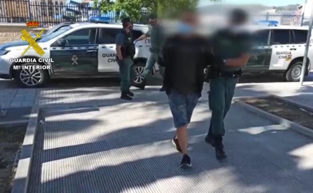 Un guardia civil con uno de los detenidos.