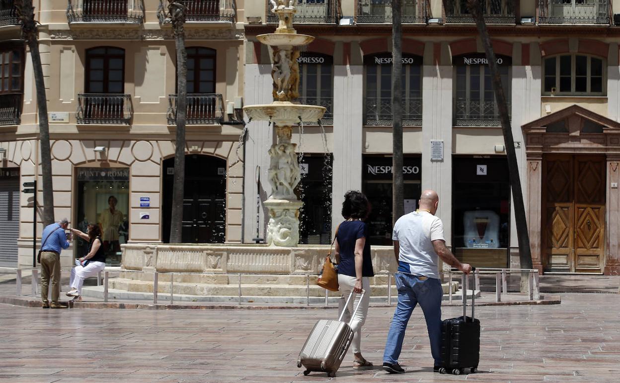 Turistas recorren con sus maletas la céntrica plaza de la Constitución de la capital de la Costa. 