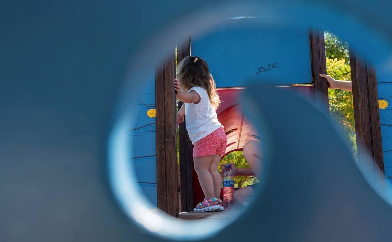 Una niña juega en un parque infantil. 