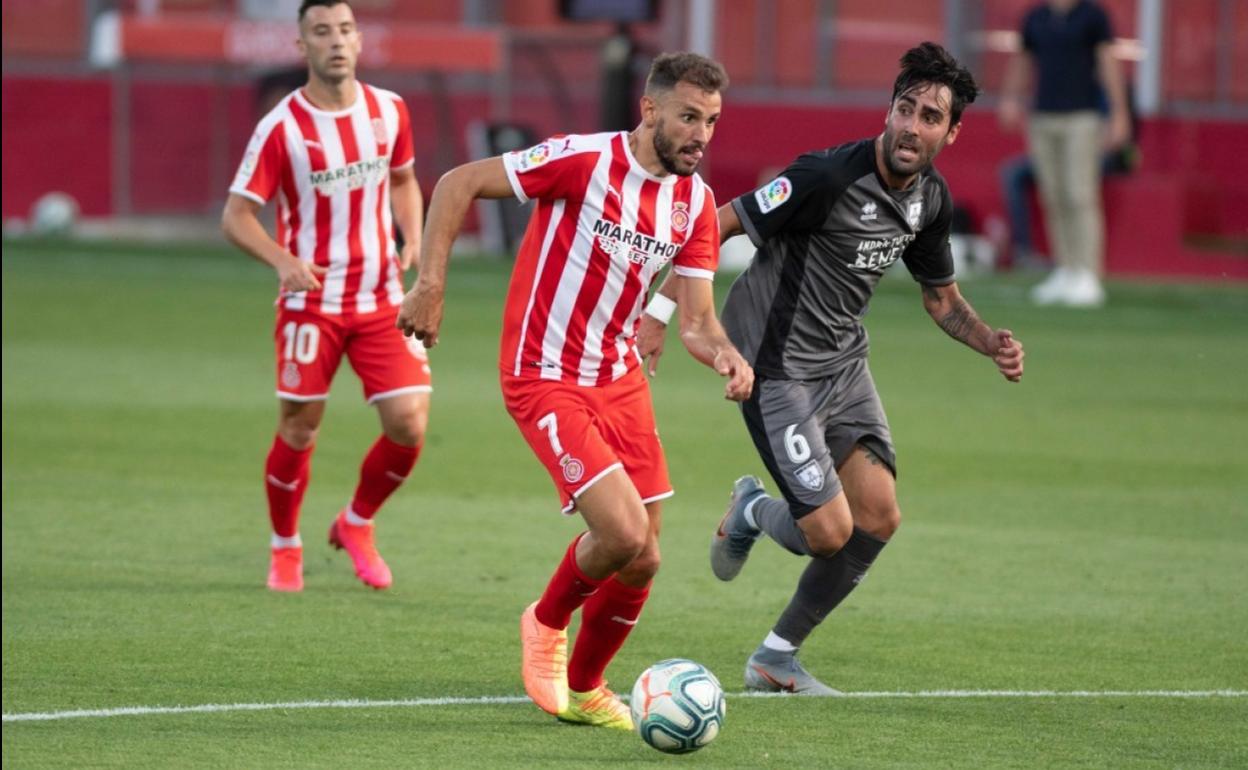 Stuani conduce el balón perseguido por el malagueño Alberto Escassi, jugador del Numancia.