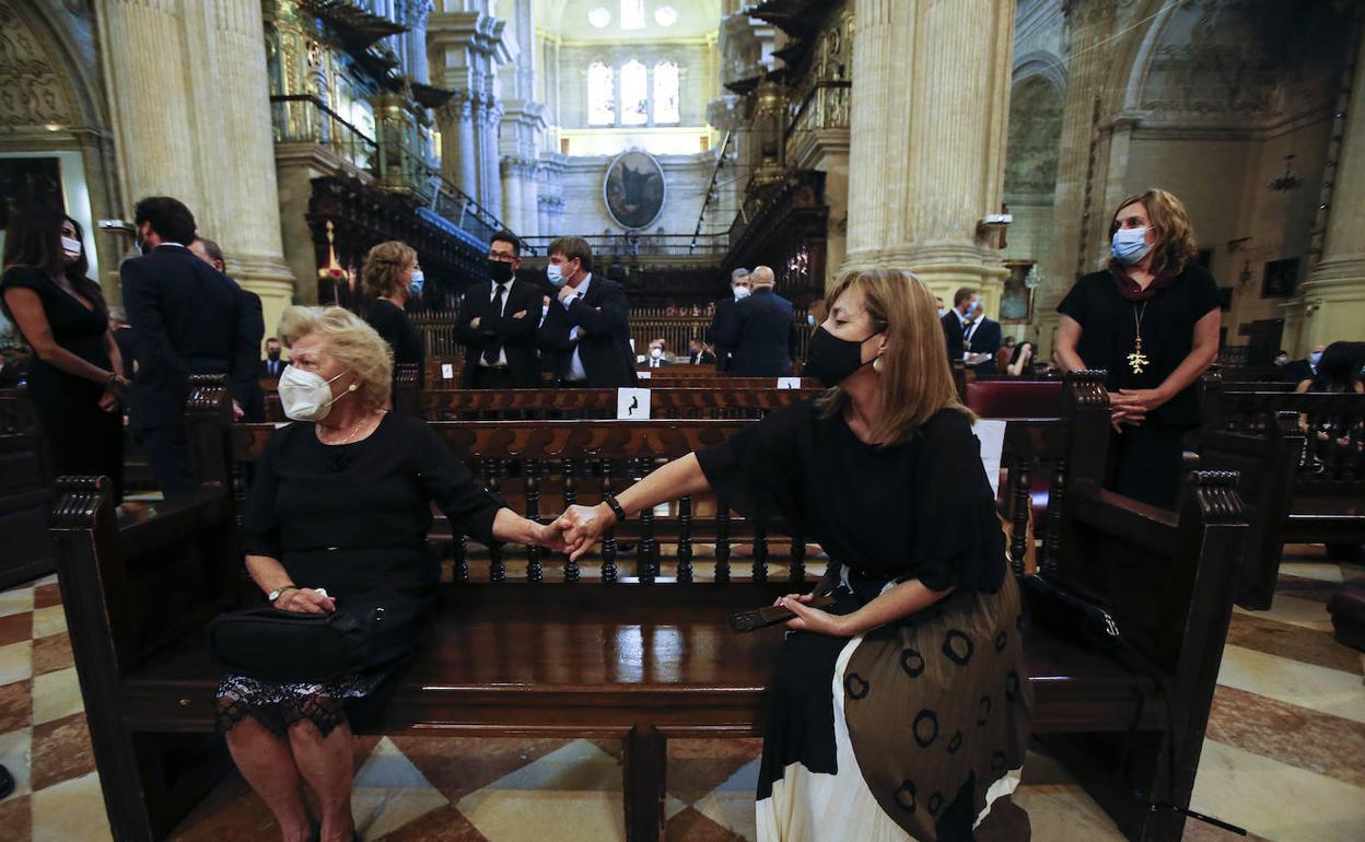 Manuela, que también se contagió, da la mano ayer a su hija Lourdes en memoria de su marido.