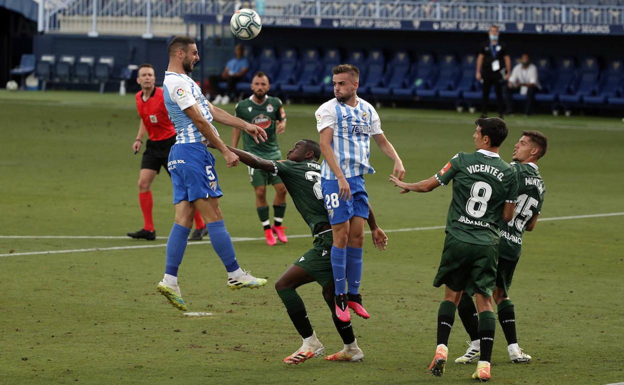 De blanquiazul, los centrales Lombán e Ismael Casas, en una jugada aérea en el partido contra el Deportivo del pasado miércoles.