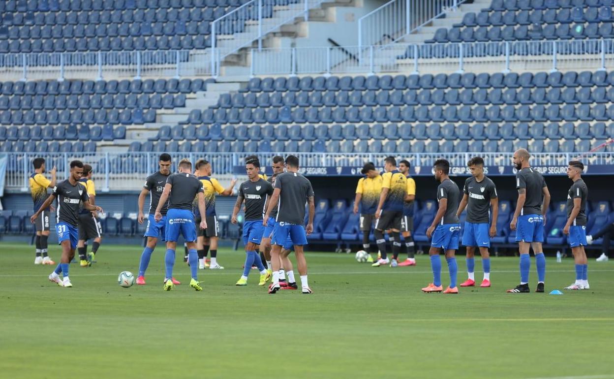 Parte del equipo malaguista durante el calentamiento del partido ante el Alcorcón. 