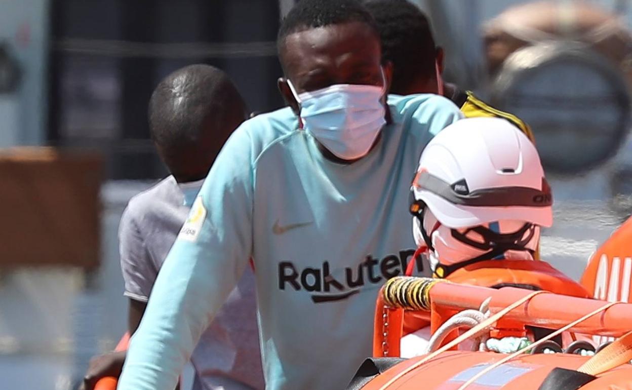 Personal de Salvamento Marítimo atiende a un inmigrante irregular. 