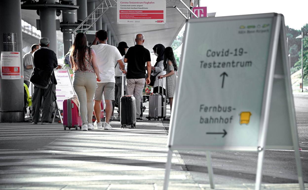 Los pasajeros hacen cola para pasar el test de coronavirus en el aeropuerto de Colonia (Alemania).