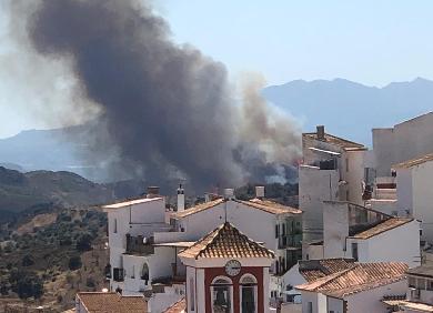 Imagen secundaria 1 - Arriba, trabajos para sofocar las llamas en Gaucín; abajo a la izquierda, columna de humo en Colmenar, y a la derecha, en Gaucín. 