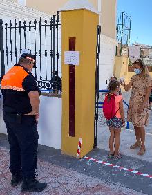 Imagen secundaria 2 - Arriba, entrada al colegio público San Miguel de Nerja; abajo a la izquierda, voluntarios de Protección Civil en Los Llanos de Torrox-Costa y a la derecha, toma de temperatura al acceder al centro nerjeño. 