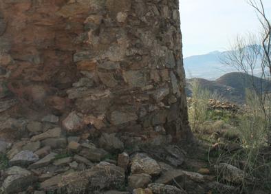 Imagen secundaria 1 - Arriba, la torre de los Verdiales se ve un kilómetro antes de llegar a ella. Abajo, esta torre fue construida en el período andalusí, y, a la derecha, al fondo se atisba la conocida como ermita de los Verdiales.