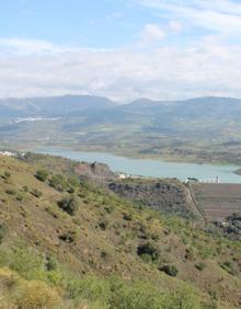 Imagen secundaria 2 - Arriba, cartel que indica el sentido en el que ir. Abajo, una de las subidas que hay que afrontar, y, a la derecha, vista panorámica de la presa de La Viñuela.