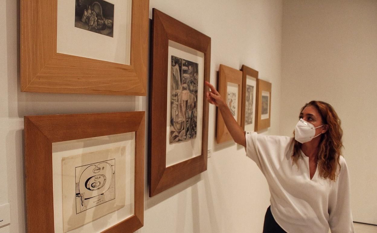 Lourdes Moreno señala una obra de Maruja Mallo durante la visita a la exposición. En primer término, una pieza de Dalí. 