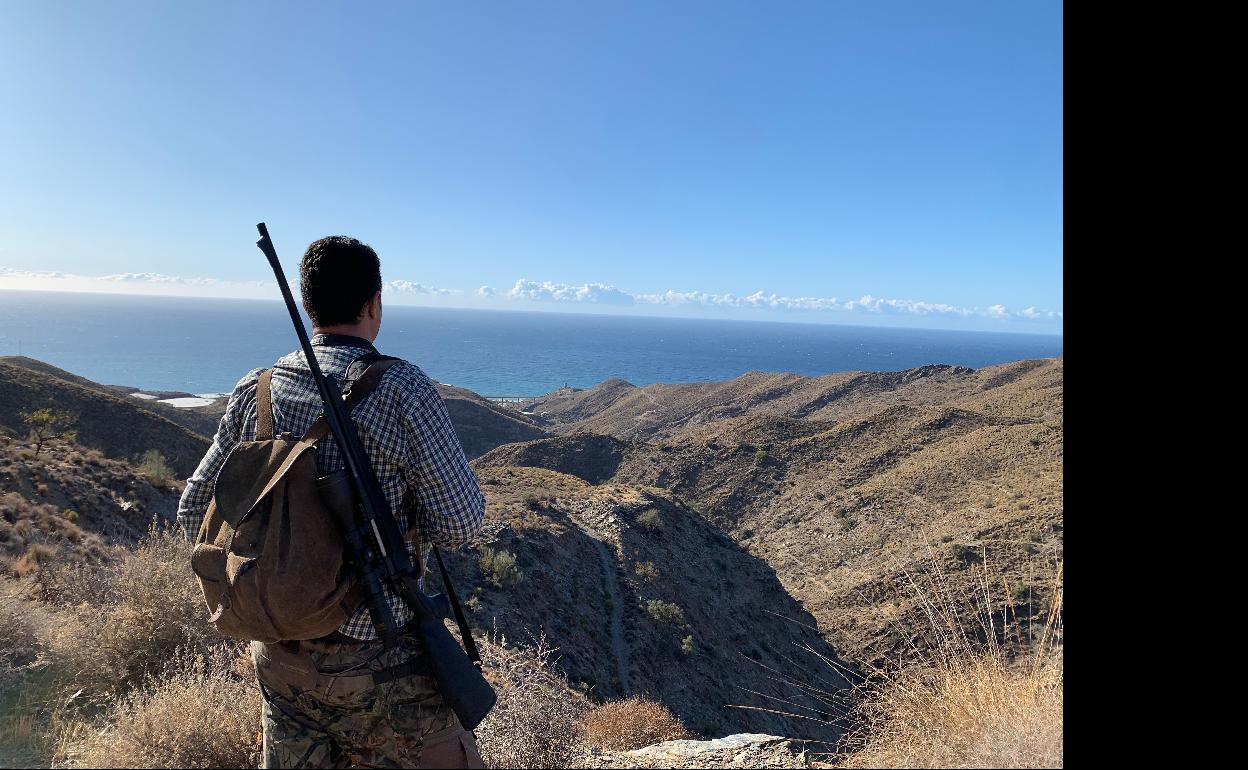 Un cazador, con su escopeta y su morral al hombro, otea el horizonte en un coto.
