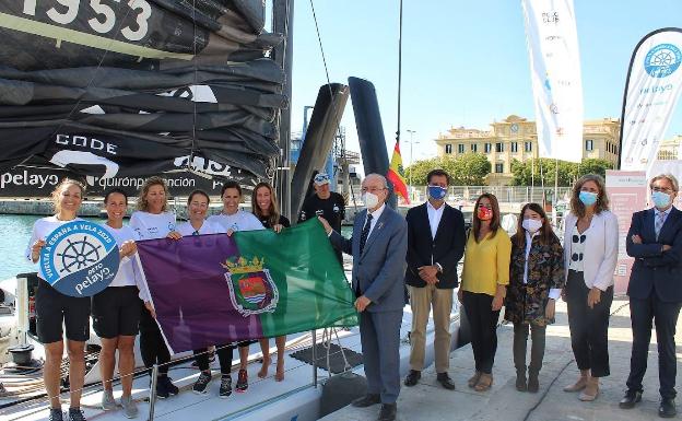 Las mujeres que tripulan el velero, con la bandera de Málaga, entregada por el alcalde. 