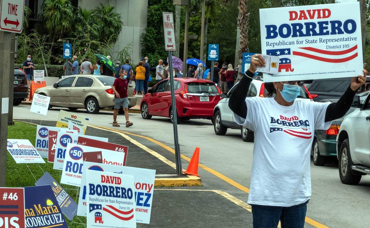 Una persona alza un cartel a favor de un candidato republicano en un centro de votación en Miami, Florida..