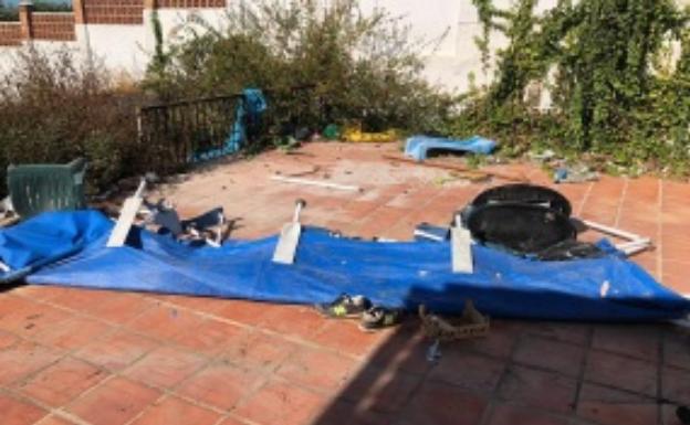 Imagen principal - Arriba, destrozos en la terraza de la vivienda; abajo a la izquierda, restos de basura y ropa en el interior de Casa Elsa; y a la derecha, la puerta destrozada. 