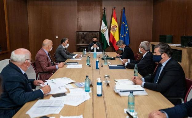 El presidente andaluz, Juanma Moreno (c), presidió en el Palacio de San Telmo la reunión del Comité Director de Alertas, donde se ha evaluado la situación actual de la pandemia del coronavirus en cada provincia. 