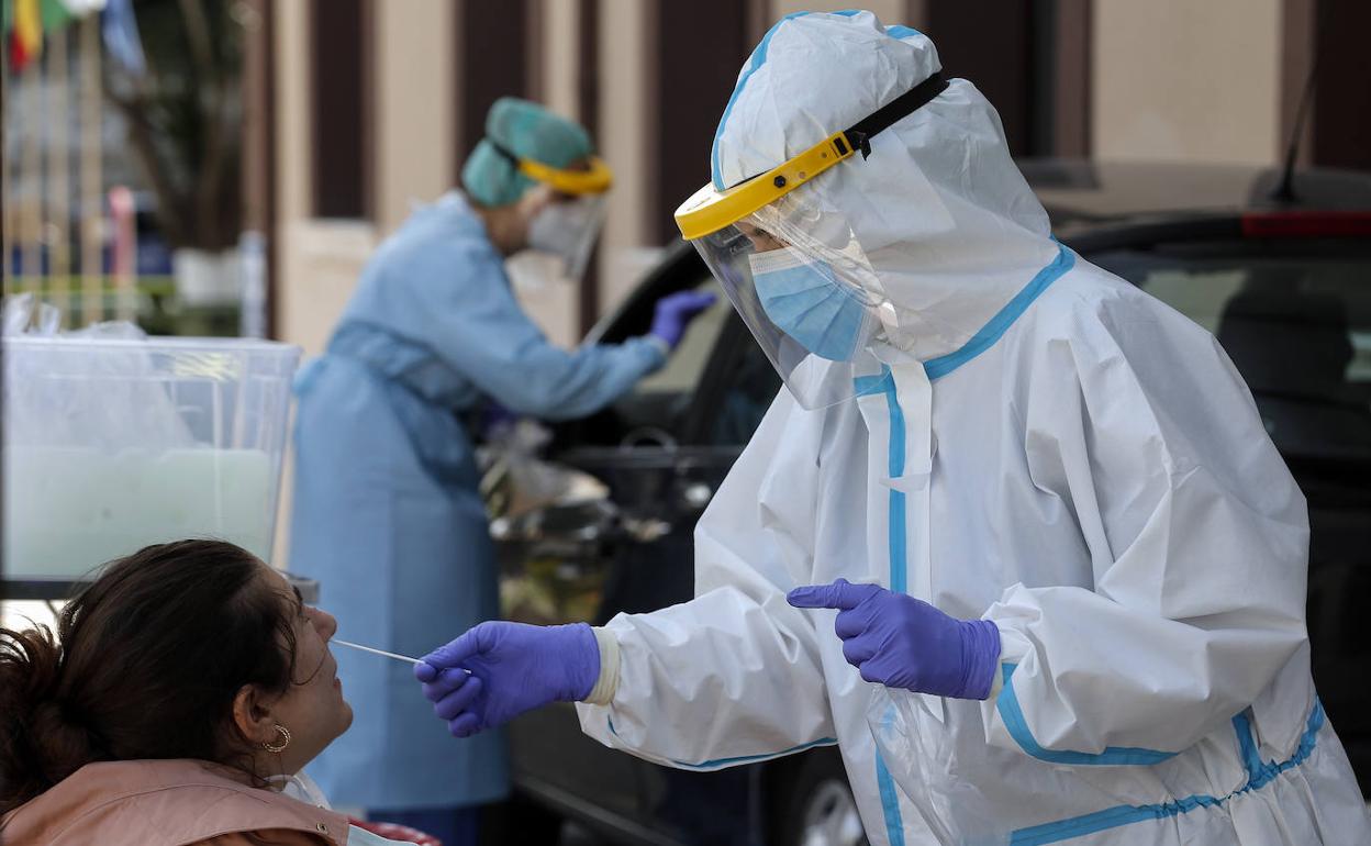 Un profesional sanitario toma una muestra para la realización de una PCR. 