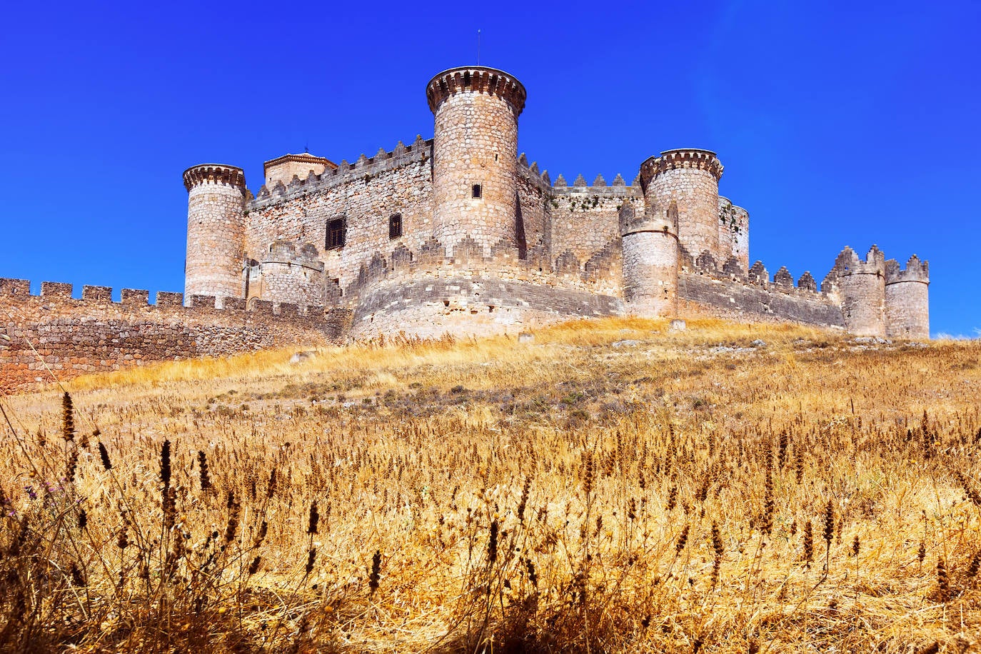 Castillo de Belmonte (España). Fue encargado por D. Juan Pacheco, Marqués de Villena, para utilizarlo como vivienda propia en su ciudad natal. Es un castillo gótico-mudéjar, obra del Maestro Hanequín de Bruselas. Se construyó sobre el monte de San Cristóbal con una planta única. El patio de armas es un triángulo equilátero y a partir de él se desarrolla el resto del edificio. La forma del castillo es una estrella de 6 puntas y al final de cada una de ellas hay una torre cilíndrica, según detallan desde la web Jetcost.es