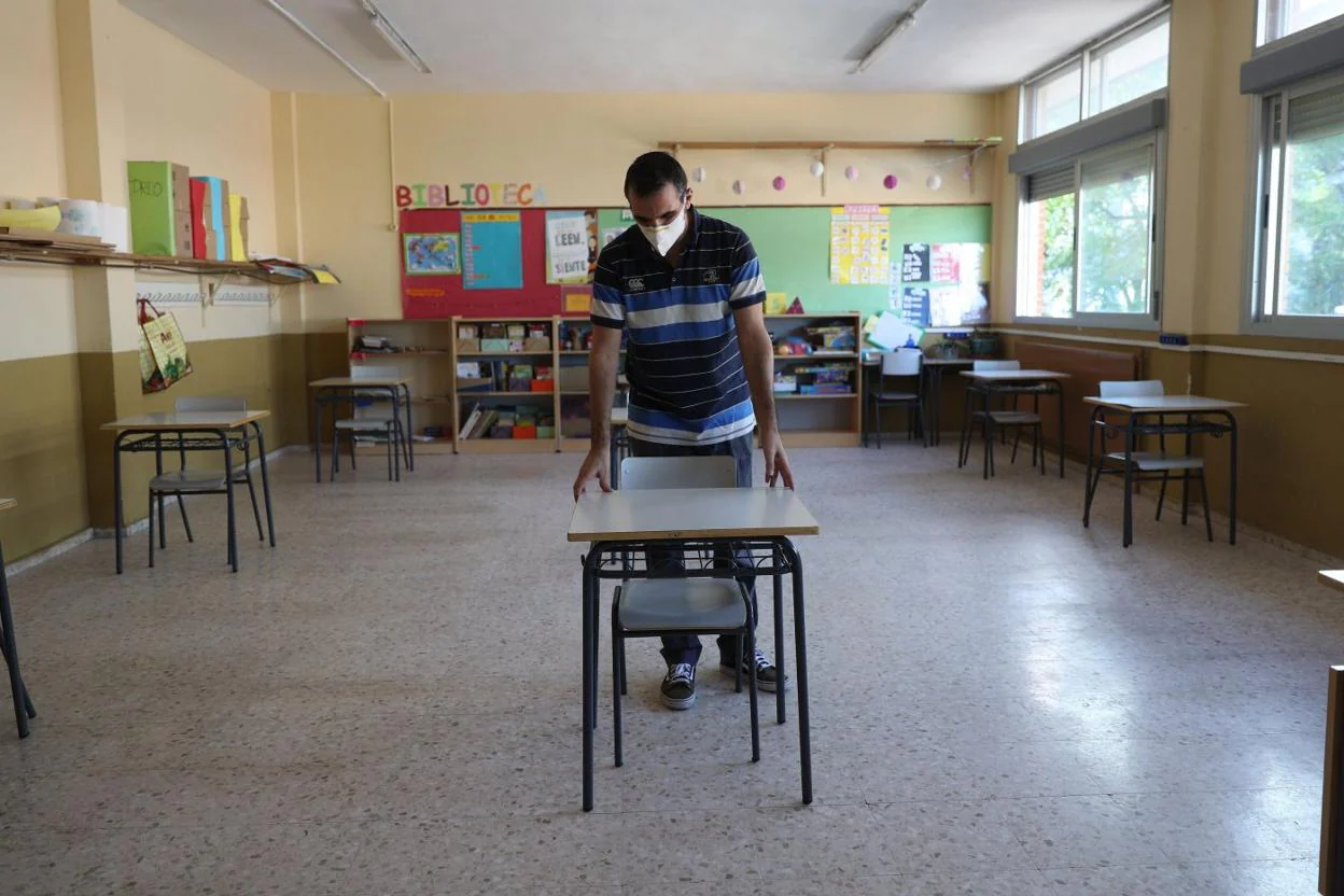 Un profesor coloca las mesas para mantener la distancia de seguridad en un centro escolar. efe. archivo