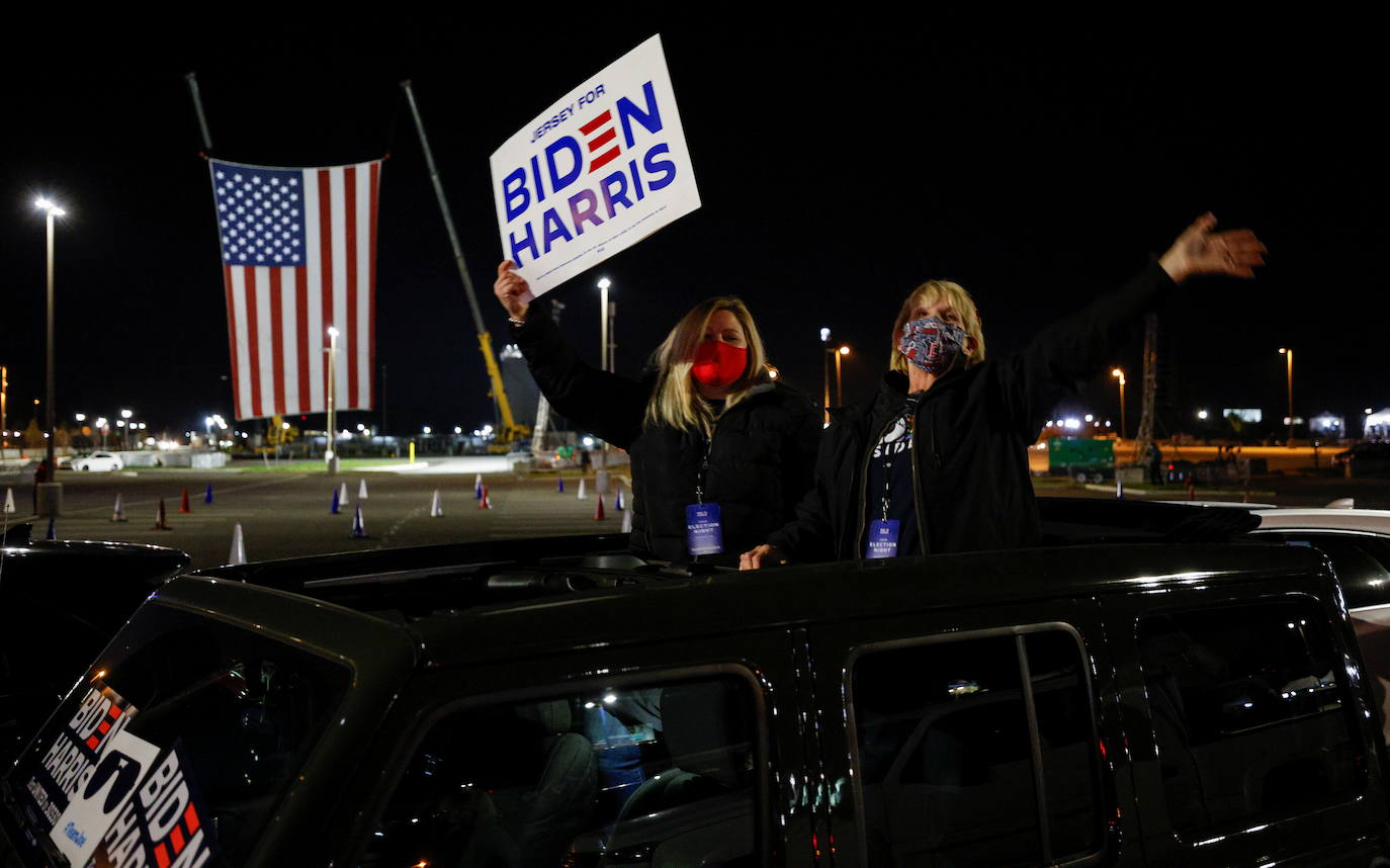 Los partidarios de Biden esperan al candidato en un aparcamiento.