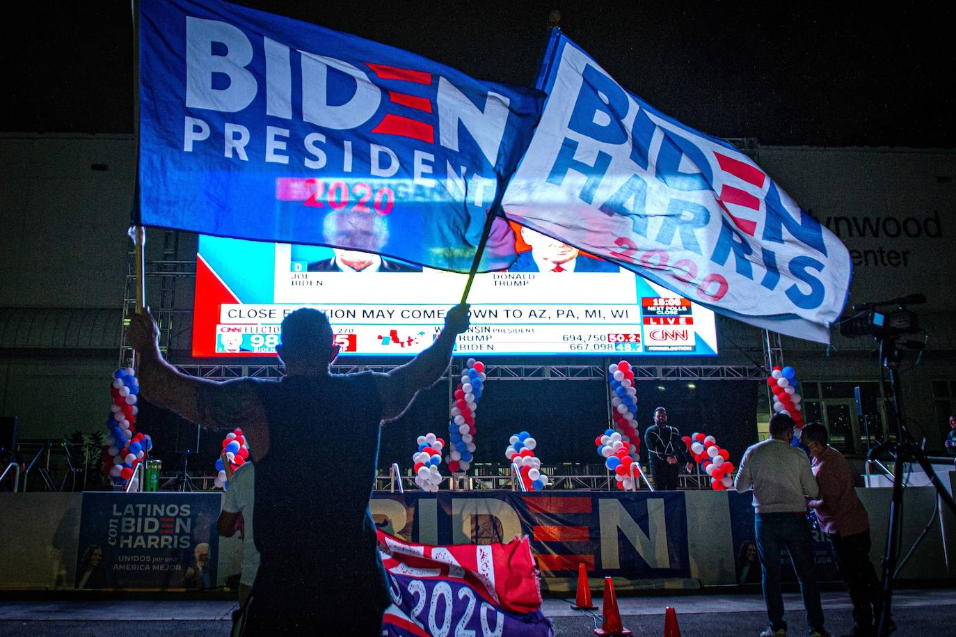 Simpatizantes de Biden ondean banderas y muestran su apoyo mientras esperan los resultados.