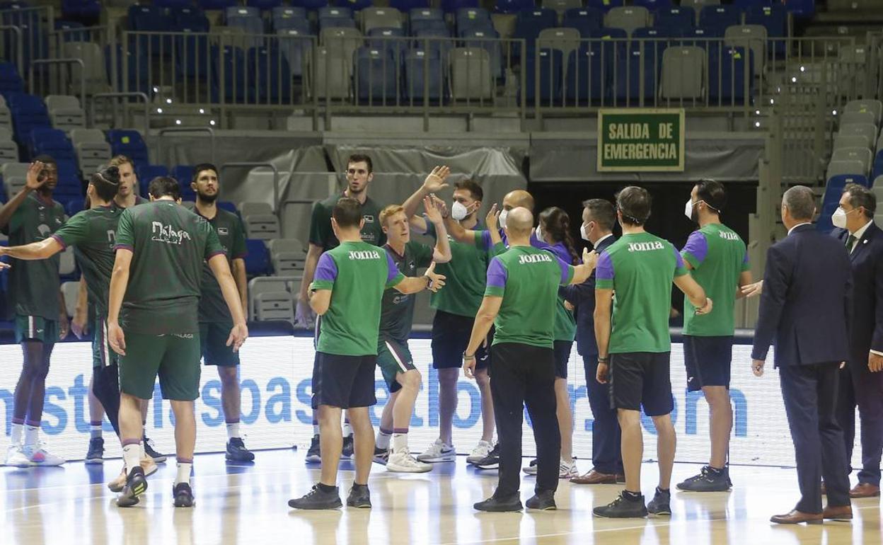 Los jugadores del Unicaja y el cuerpo técnico, durante una presentación en el Palacio de los Deportes. 