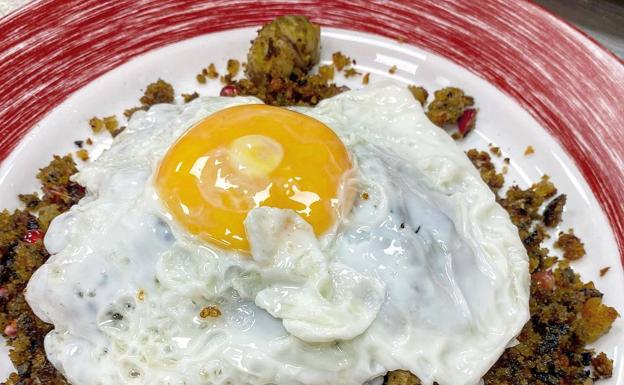 Migas de pan de boletus con castañas confitadas, granadas y huevo frito del hotel restaurante Bandolero 