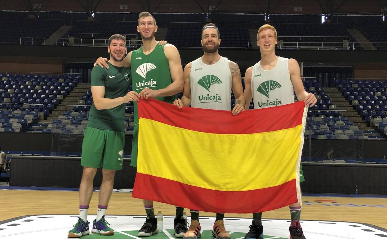 Los cuatro internacionales del Unicaja posan con la bandera española. 