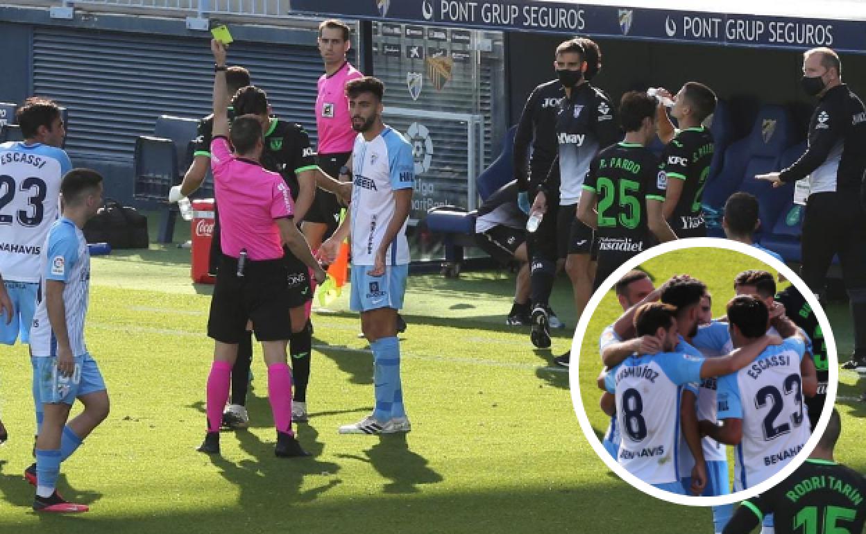 Juande recibe tarjeta amarilla después de que el VAR señalase falta sobre Arnáiz y penalti. En el círculo, jugadores del Málaga abrazan a Juande tras su gol que valió para poner el 1-1.