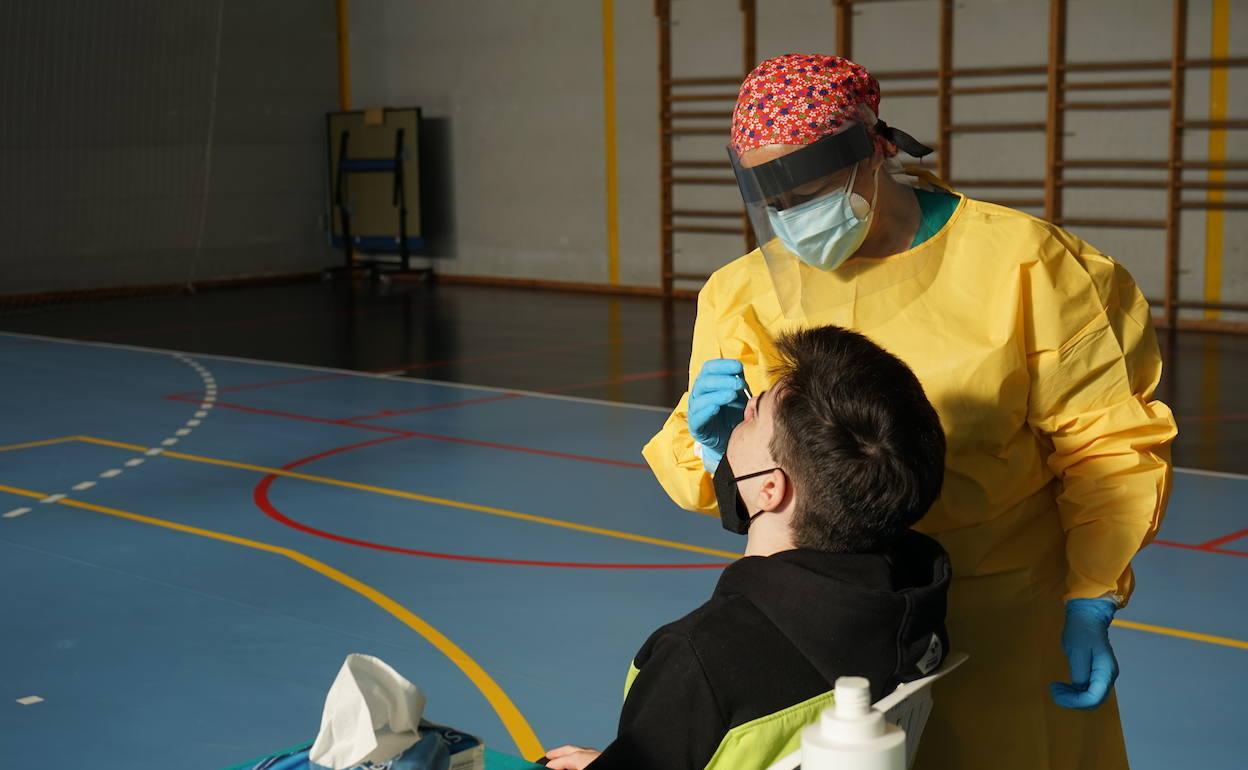 Una sanitaria toma una muestra en un cribado de la población. 