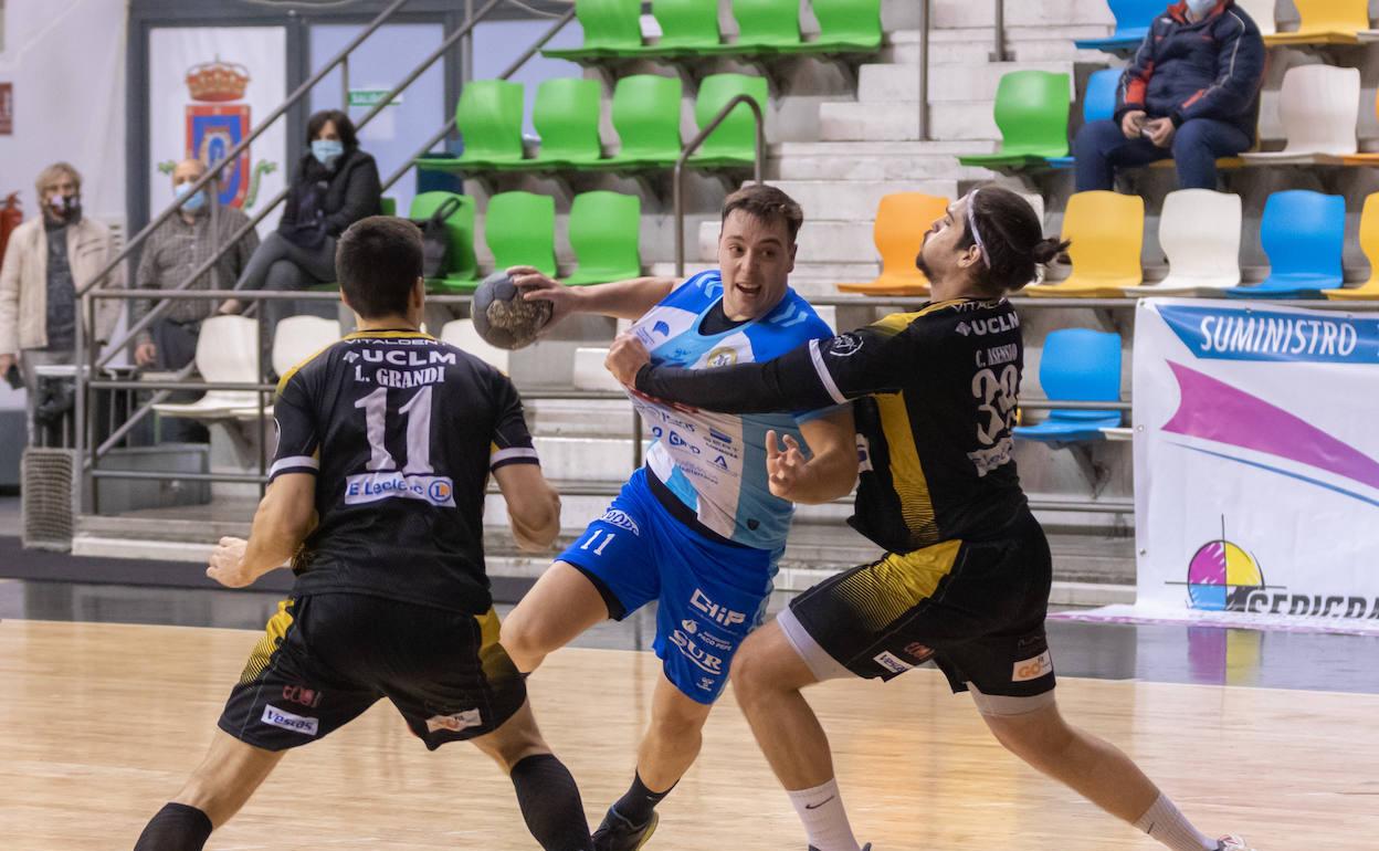 Carlos González trata de penetrar defendido por dos jugadores del Alarcos. 