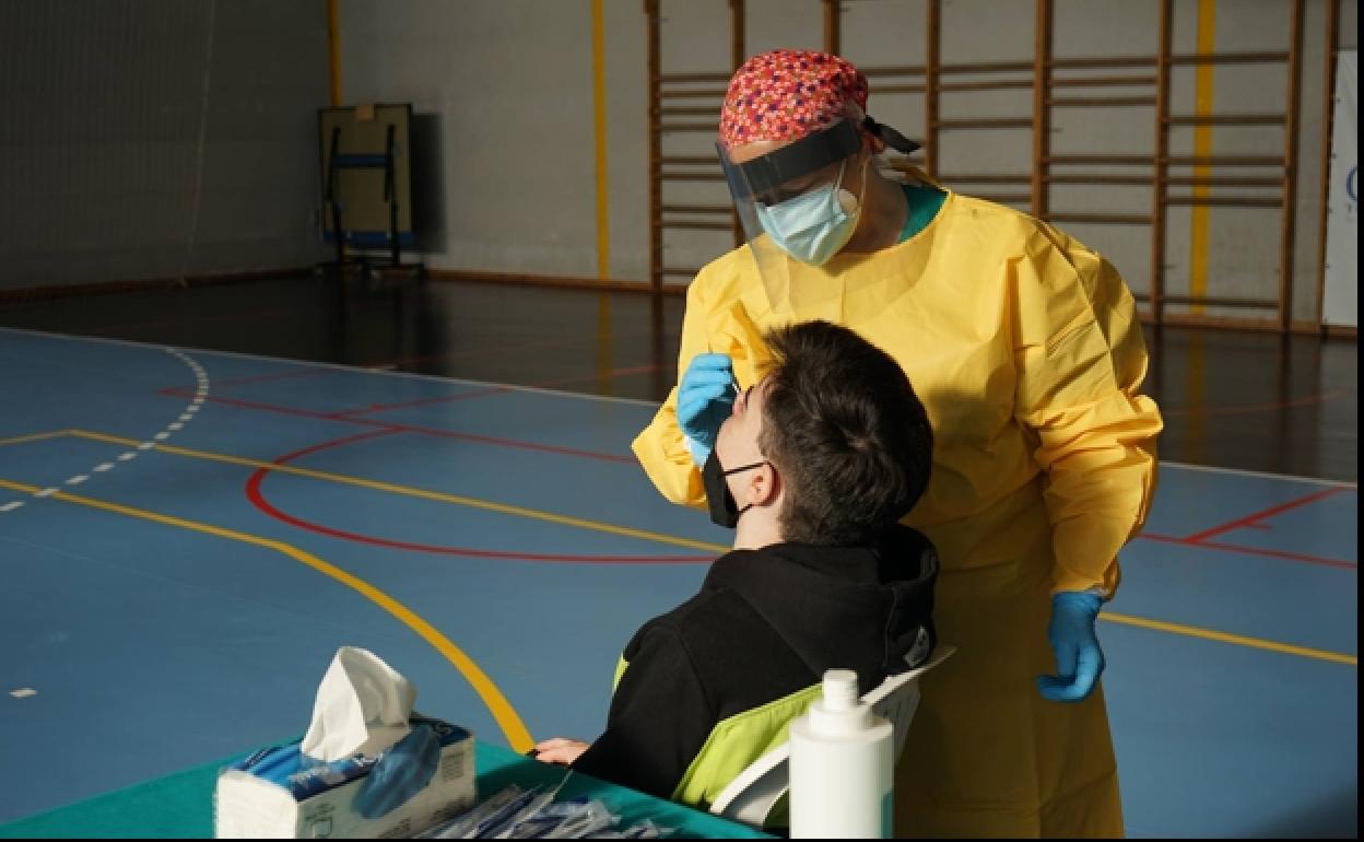 Una sanitaria toma una muestra en un cribado de la población. 