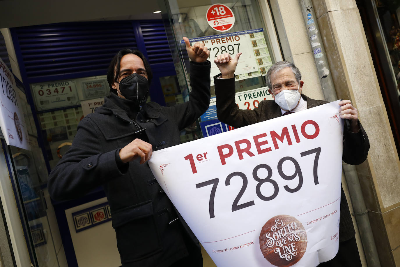 Loteros posan en la administración de lotería situada en la calle Principe 11, en Granada, en la que se ha repartido parte del número '72897´ correspondiente a 'El Gordo' de la Lotería de Navidad