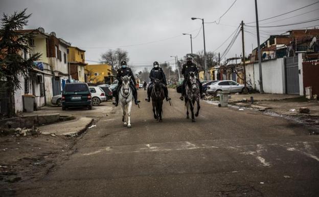 Imagen principal - 1) La Policía Nacional patrulla a caballo por una calle en Cañada Real. 2) Houda Akrikez posa en el exterior de la asociación Tabadol. 3) Varias bombonas de butano con el nombre de los vecinos a los que van destinadas.