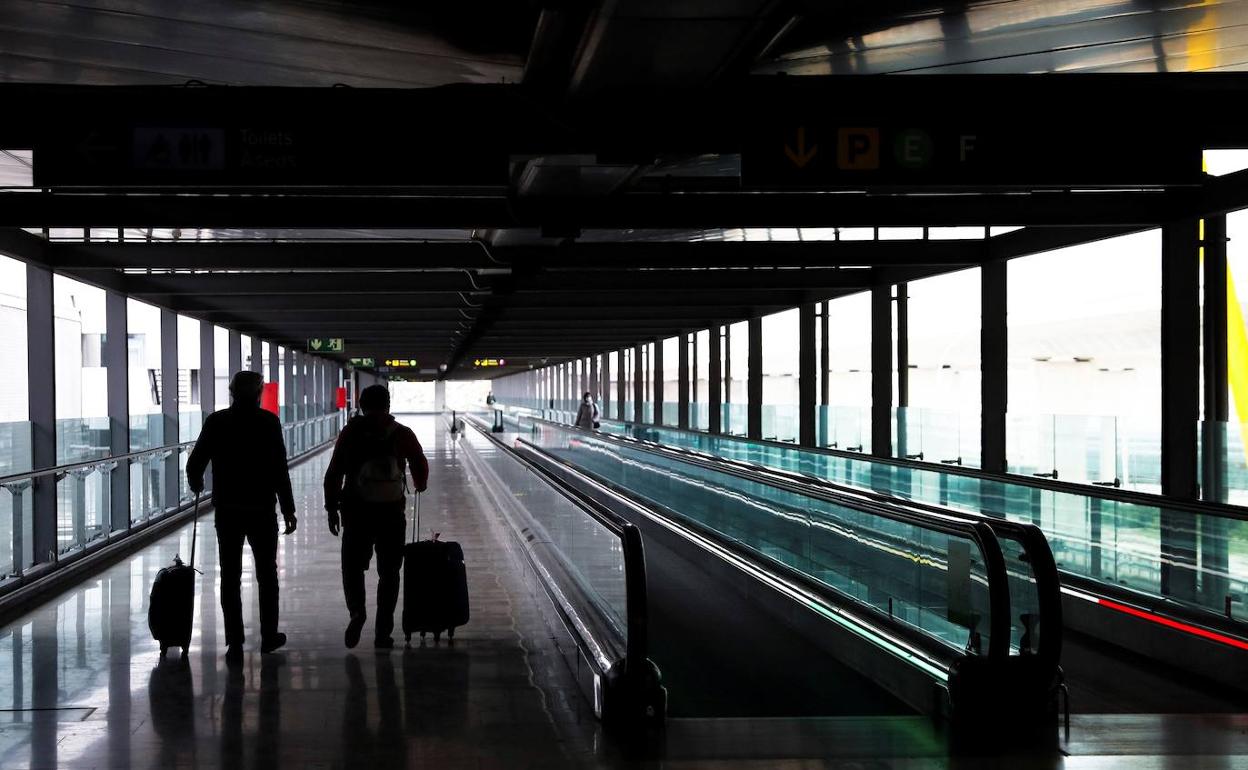 Turistas se desplazan de una terminal a otra del aeropuerto. 