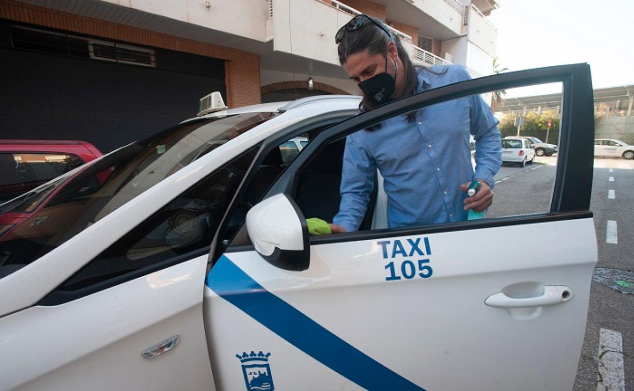 Jesús Báez limpia las zonas de contacto de su taxi con un producto antibacteriano. 