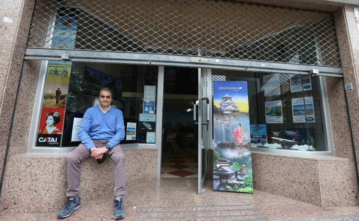 Miguel Velasco, a la entrada de su agencia, con la persiana echada a la mitad