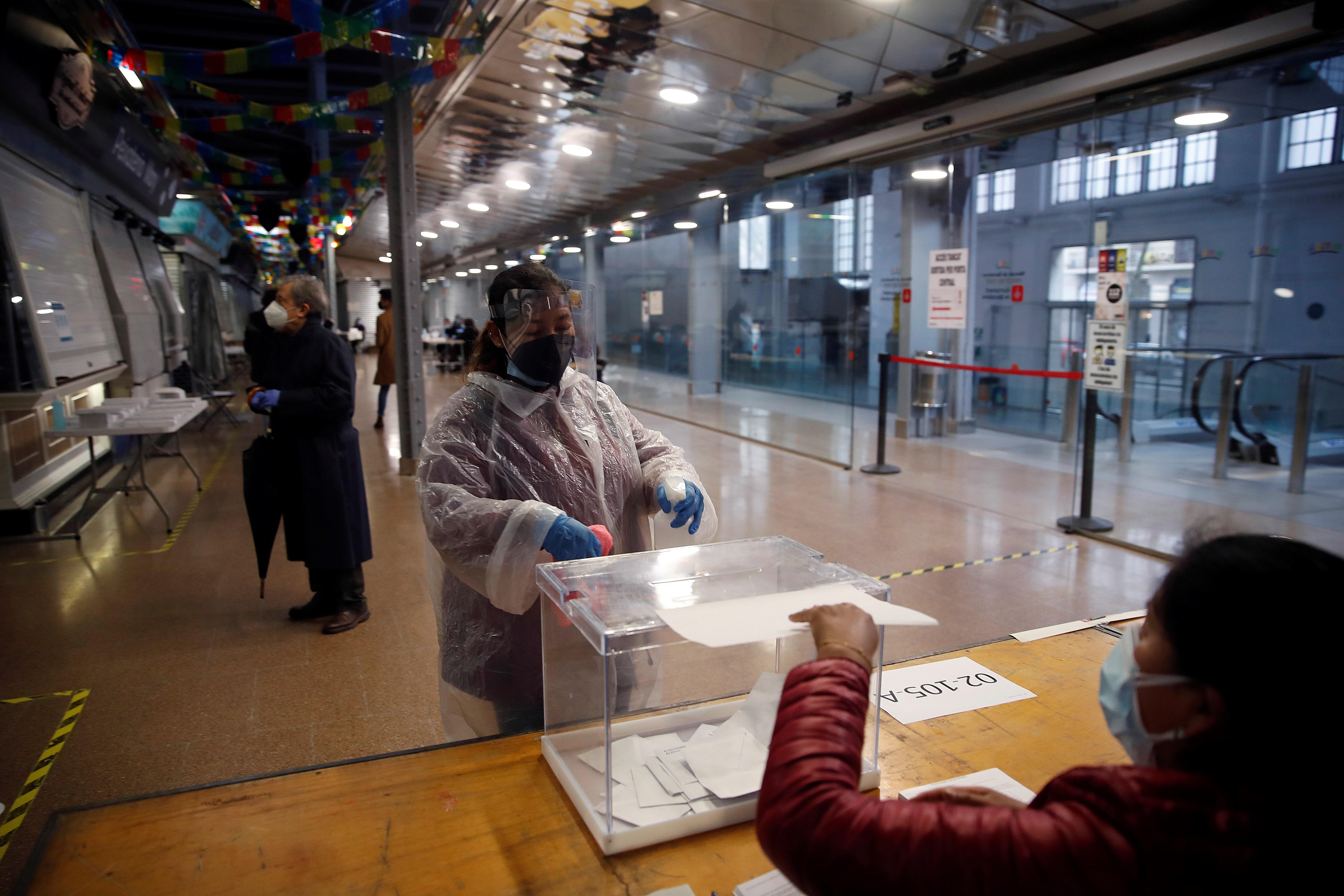 Una mujer totalmente protegida acude a votar a su mesa electoral en el Mercat del Ninot, en Barcelona. 