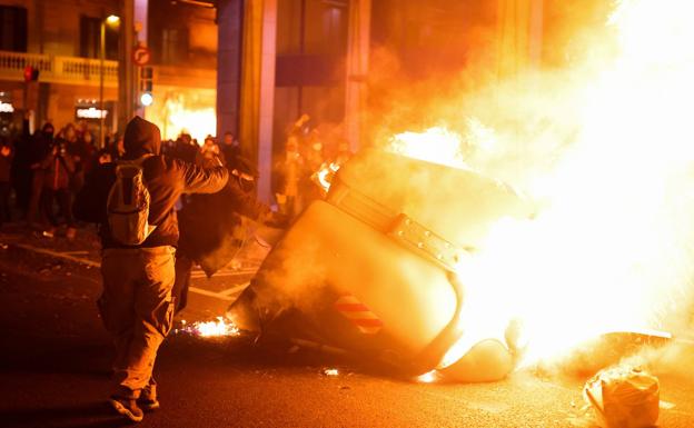 Imagen principal - Los incidentes se saldaron con la quema de contenedores, heridos -en la imagen una mujer herida en un ojo en Barcelona, y lanzamiento de objetos contra los Mossos.