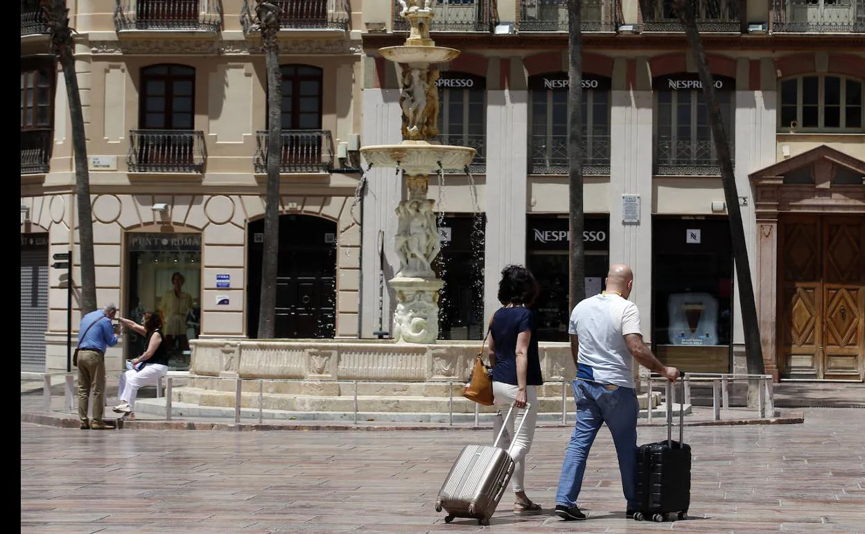 Turistas se dirigen hacia unos apartamentos del Centro Histórico de Málaga. 
