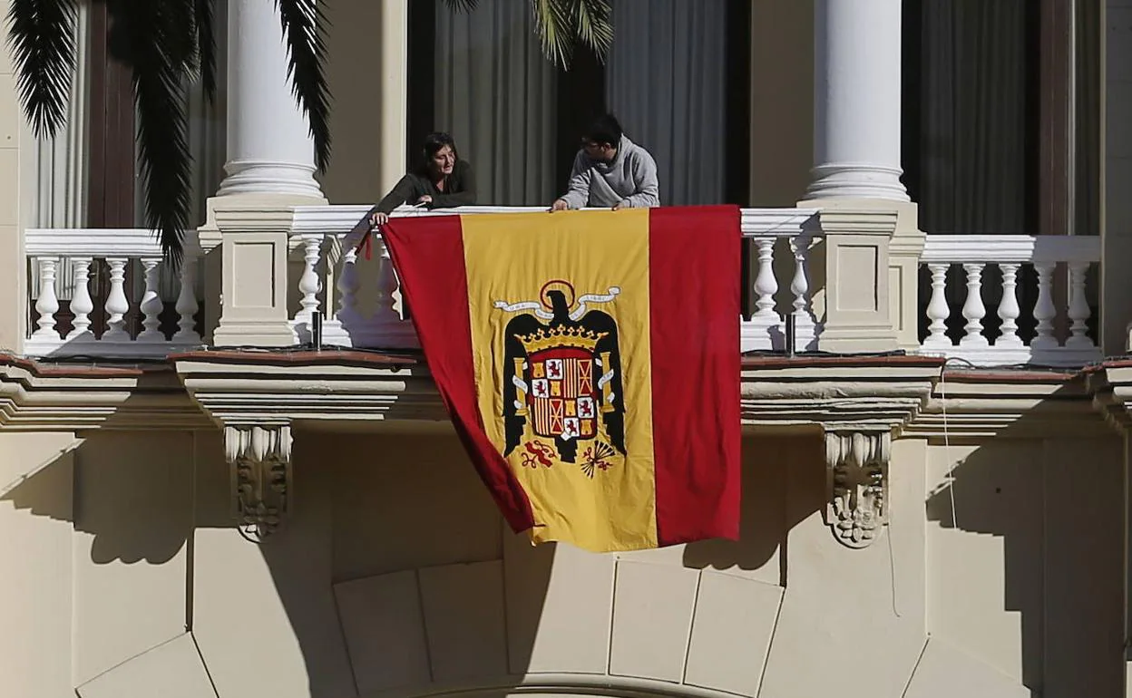 Operarios colocan la bandera franquista en la fachada del Ayuntamiento para el rodaje de la película. 