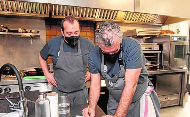 Imagen principal - Dani ajustando el menú de ese día con Miguel Manzanares, su jefe de cocina. Abajo, calamar Kru y pastel de pularda (izquierda), .