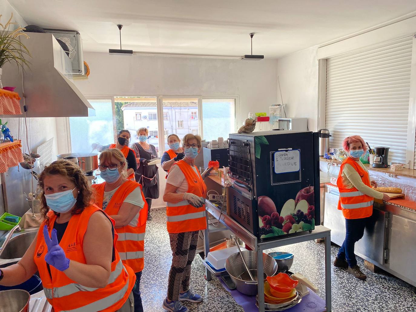 Las voluntarias, con preparativos de comidas para ayudar a las personas sin hogar. 