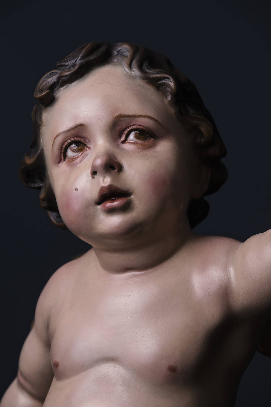 Rostro del ángel que sostiene con su mano el vértice inferior de la cruz del Cristo. 