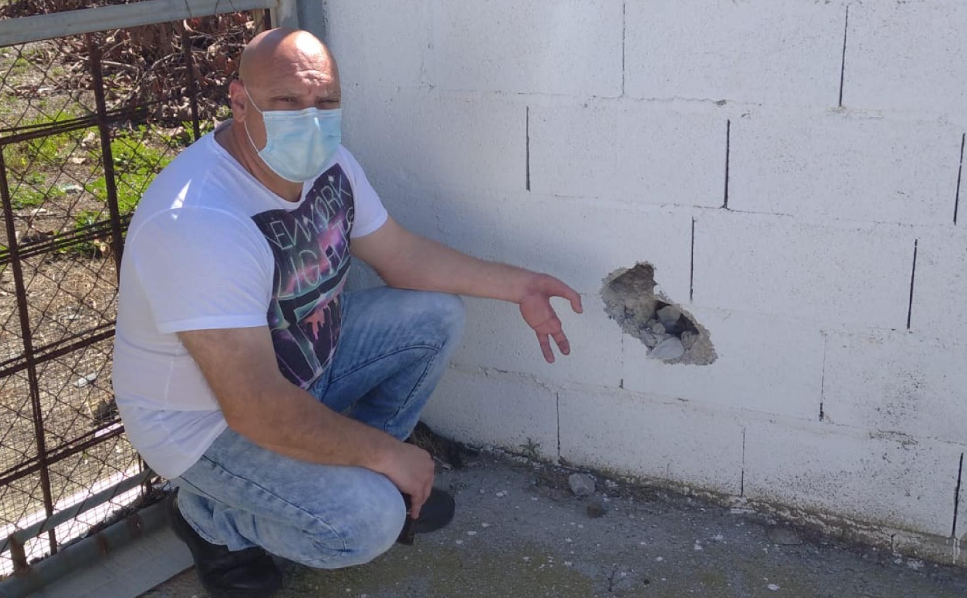 Antonio, en el lugar de la explosión, junto a un destrozo que hizo la bomba en un muro de hormigón. 