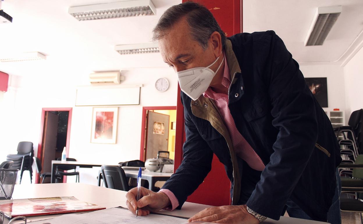 Un profesor firma en el libro que registra la hora de entrada y salida en un instituto de la capital. 